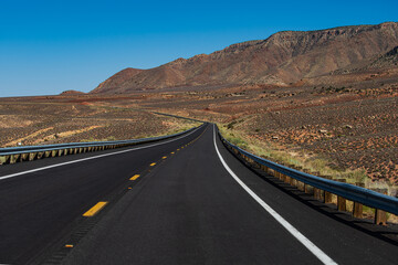 American roadtrip. Landscape with orange rocks, sky with clouds and asphalt road in summer.