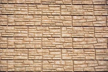 Texture of decorative tiles on the wall. Decoration of house walls with artificial stone.