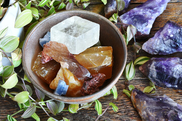 A top view image of a pottery bowl full of various calcite crystals with Canadian amethyst crystals.
