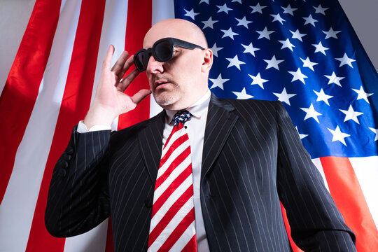 An officer of American intelligence. A man in a tie with an American flag and black glasses. USA intelligence. An employee of the FBI in the service. An American with glasses and a built-in microphone