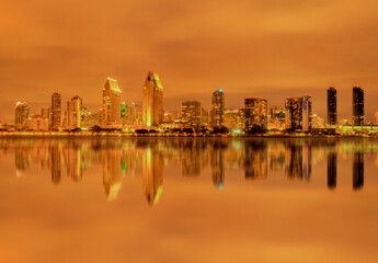 City Skyline Reflected in Ocean and Brightly Illuminated Due to City Lights Refracting from Dense Clouds