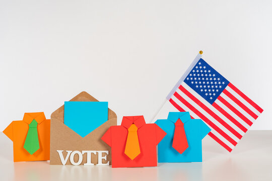 Voting in the US Presidential election. Symbolic origami men next to the word vote and the American flag. The concept of voting participation. Elections of the President in USA.