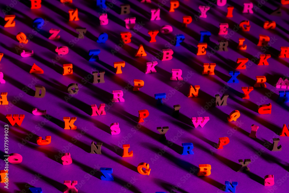 Fototapete many letters of the latin alphabet. english letters on the table are illuminated from the side. lati