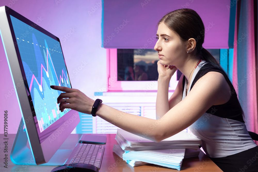 Poster the girl is studying graphics on the computer. data analysis. dynamics of financial indicators of th