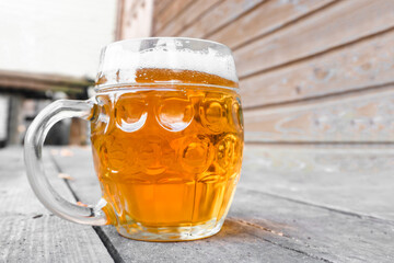 A beer mug stands on wooden planks