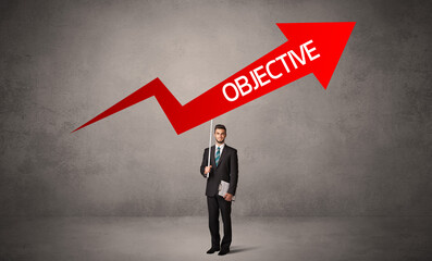 Fototapeta premium Young business person in casual holding road sign with OBJECTIVE inscription, business direction concept