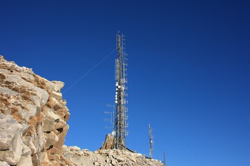 communication, telecommunication and television antennas, positioned between the rocks of the...