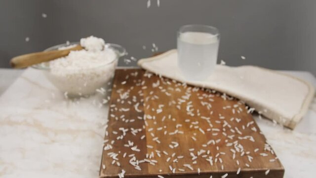 Falling seeds on table with glass of rice water