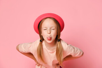 Mischievous little girl leaning forward with hands on hips and lolling while teasing or trolling...
