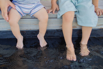 足湯につかる日本人の赤ちゃんと幼稚園児の兄弟 - obrazy, fototapety, plakaty