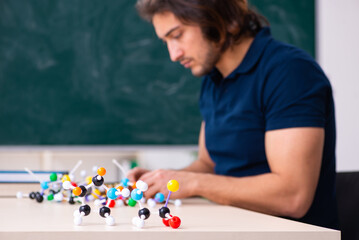 Young male scientist sitting in the classroom