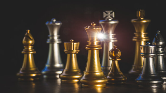 Gold queen in battle chess game stand on chessboard with flare light.Concept of business leader market target strategy. business competition success, strategy ideas and Intelligence challenge concept.