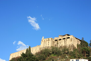 ancient ducal fortress perched on a green hill. building overlooking the plain in the blue sky in Tuscany