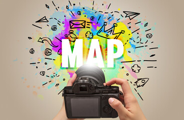 Close-up of a hand holding digital camera with abstract drawing and MAP inscription