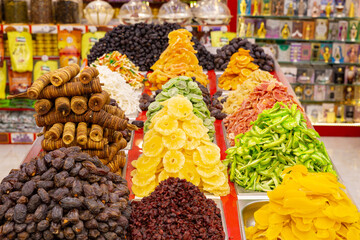 piled up and displayed colorful dried fruits in souvenir shop in the market of dubai, uae