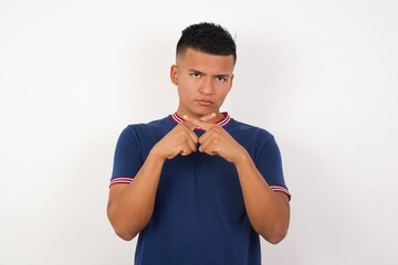 Young handsome hispanic man wearing casual t-shirt standing over white isolated background Has...