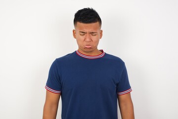 Obraz premium Dismal gloomy rejected Young handsome hispanic man wearing casual t-shirt has problems and difficulties, curves lower lip and closes eyes in despair, being in depression after desperate attempts 