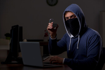 Male hacker hacking security firewall late in office