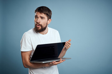 Man shows open laptop keyboard monitor emotions model blue advertising background Copy Space