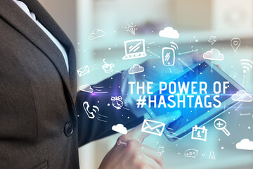 Close-up Of A Person Using Social Networking with THE POWER OF #HASHTAGS inscription