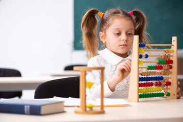Small girl with abacus in the classroom