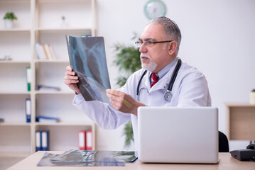 Old male doctor radiologist working in the clinic