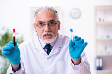 Old male chemist working in the lab