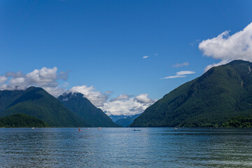 blue mountain lake with green mountains blue sky and white clouds