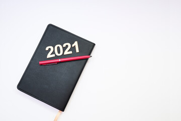 2021 text on block letters with a pen on a notebook on white background 