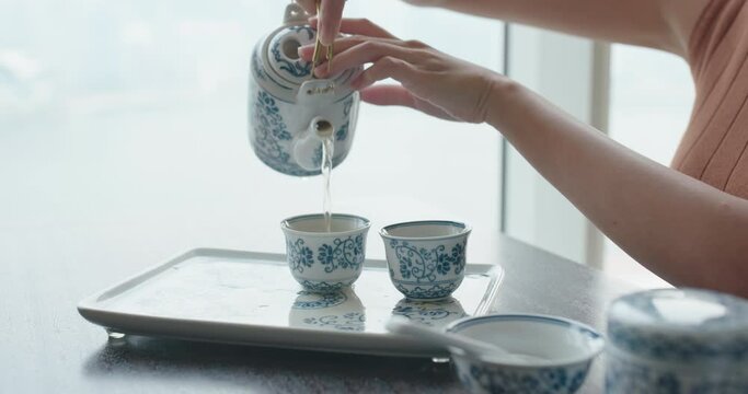 Woman having Chinese tea ceremony at home