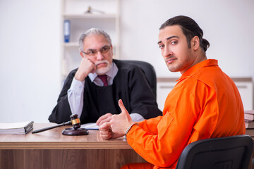 Old male judge meeting with young captive in courthouse