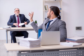 Old boss and his young assistant working in the office