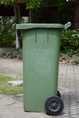 Fototapeta na wymiar green plastic bin in nature garden