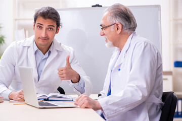 Experienced doctor teaching young male assistant