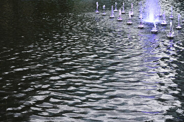 少しだけ水が出ている噴水と波紋の美しい水面