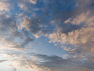 Fototapeta na wymiar Whimsical clouds in the blue sky. Summer evening