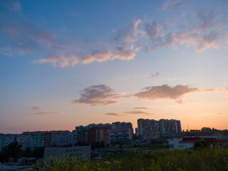 Fototapeta na wymiar Huge beautiful sunset sky over new houses in the steppe. Development of modern cities