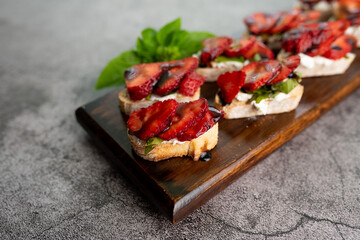 Bruschetta Sandwich with strawberries, soft goat cheese, basil and balsamic glaze, served as an appetizer 