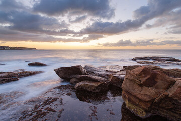 Sea water flow between rocks on the coastline.