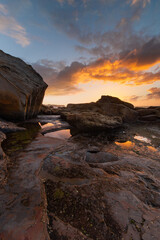Fototapeta na wymiar Sunrise view over the rock formation on the coast.