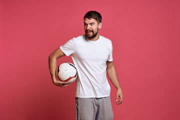 Man with a soccer ball on a pink background energy gesticulate with his hands coach emotions model