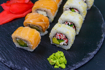 Set of sushi rolls on a black stone slate