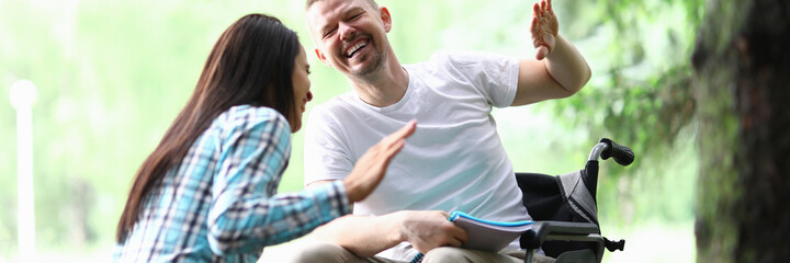 Male disabled man with girlfriend smiling on park walk portrait. Social disabitity adaptacion...