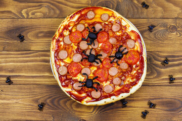 Halloween pizza with spiders on wooden table. Top view