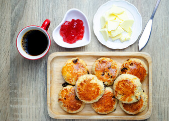 Scone homemade with with strawberry jam and butter. Traditional English backgrounds above