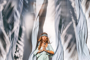beautiful young fashionable woman with huge blue fabric swinging on a wind - obrazy, fototapety, plakaty