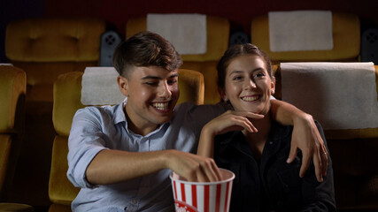 Men and women are eating and tossing popcorn was fun into their mouths in theater