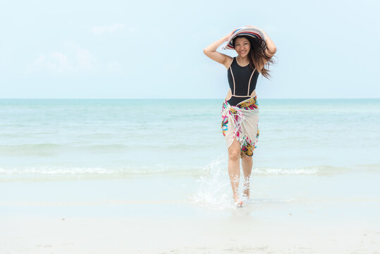 Summer Vacation. Lifestyle woman walking relax and happy on beach tropical outdoor in summer day. Young people luxury and travel destination in holiday. Tourism chill leisure of trips
