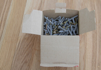 A box of screws on wooden background