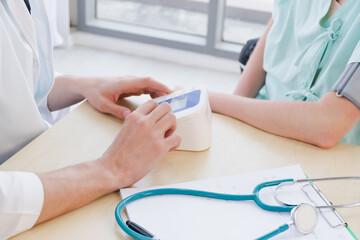 A doctor is examining the heartbeat of the patient